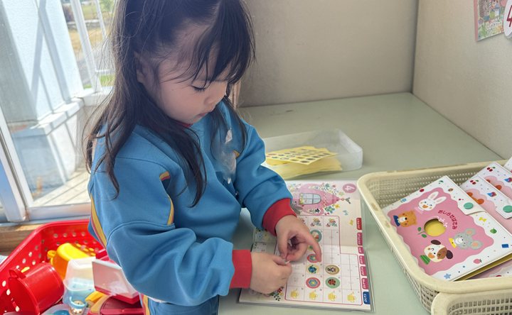 A child putting up their attendance sticker on arrival