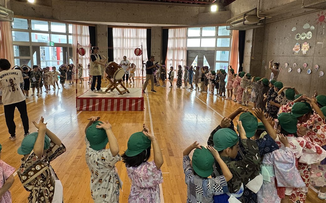 Children in yukata and jinbei dancing to the beat of the taiko drum