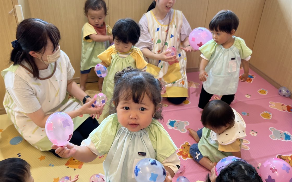 Children and their teachers playing with balloons