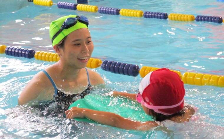 An instructor teaching a child to swim in the indoor heated pool